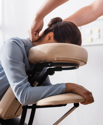 Employée recevant un massage relaxant sur une chaise spéciale au bureau.